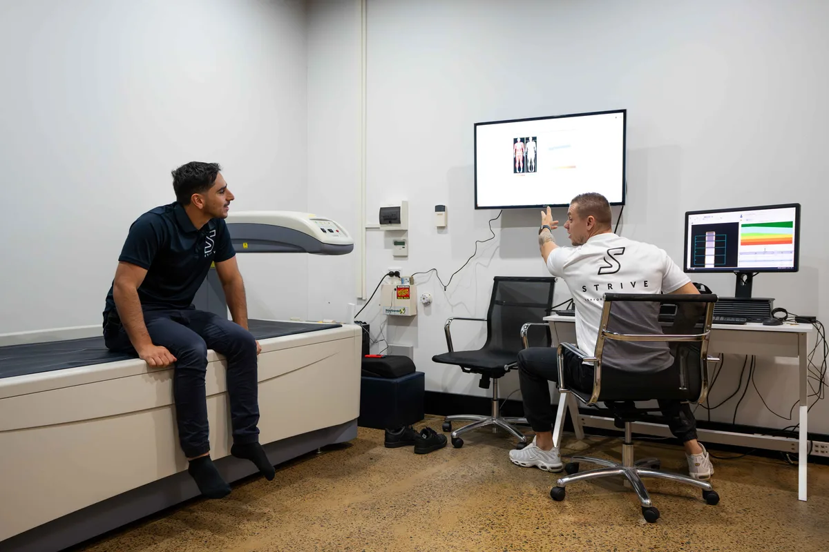Two people discussing a scan report at STRIVE Performance Dietetics.
